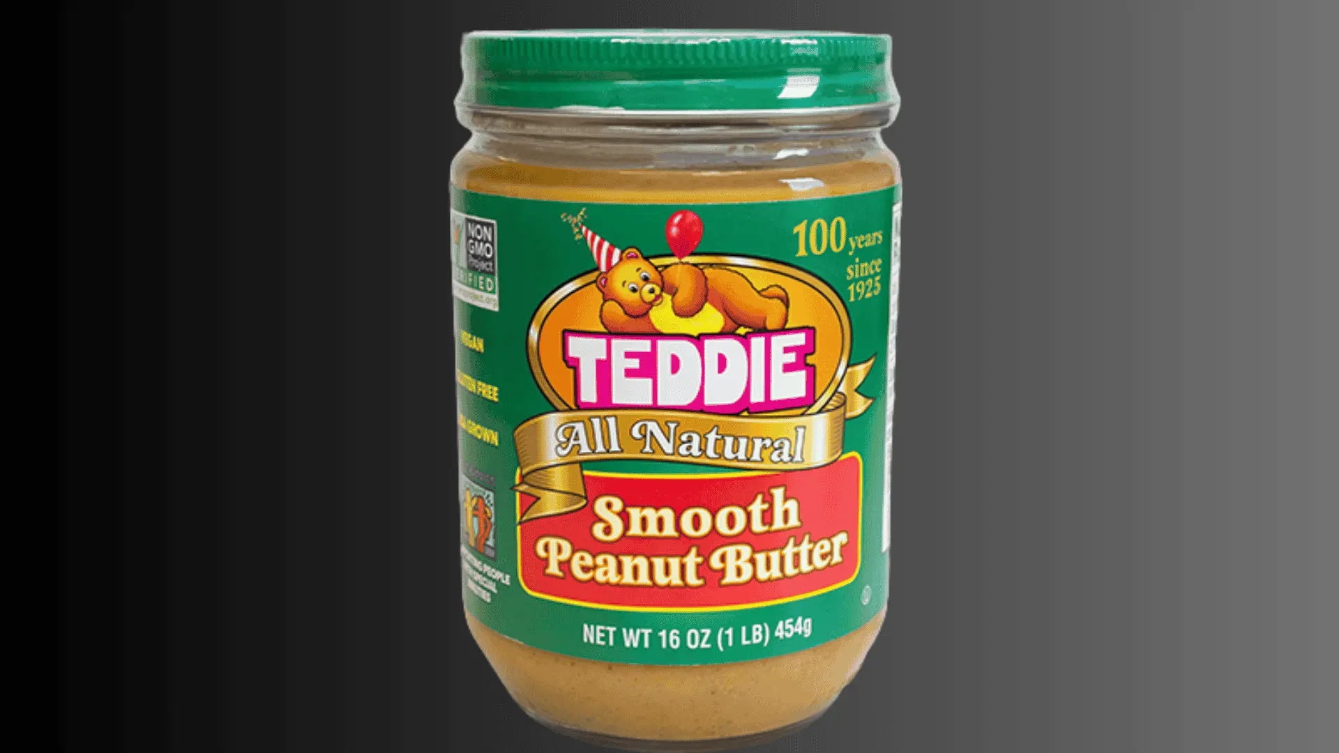 Jar of Teddie Smooth Peanut Butter with green lid against a gray background