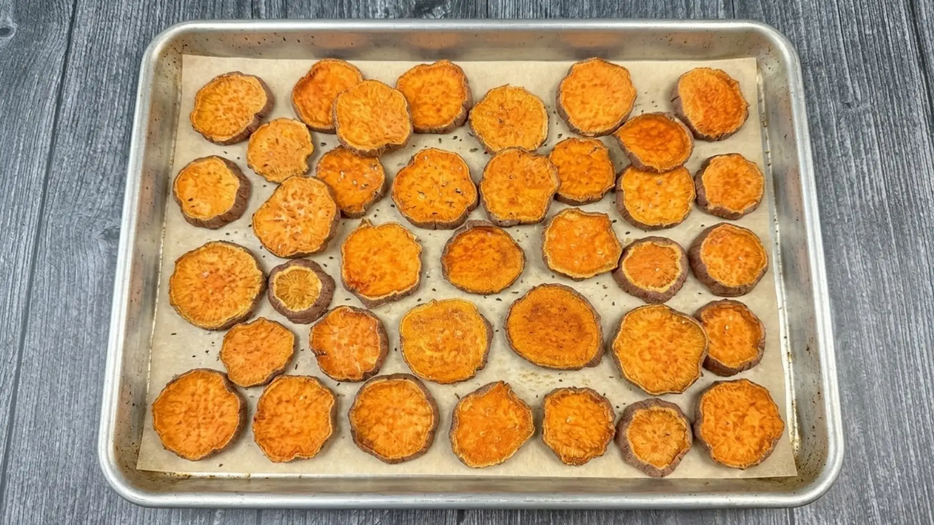 Roasted sweet potato slices arranged on parchment-lined baking sheet