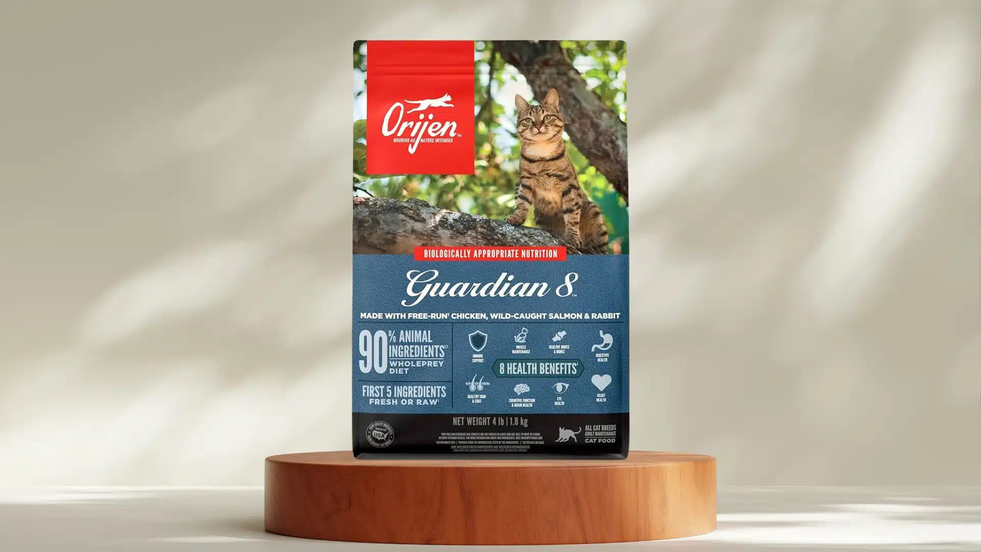 Orijen Guardian 8 dry cat food bag on wooden stand with tabby cat image and blue label showing health benefits