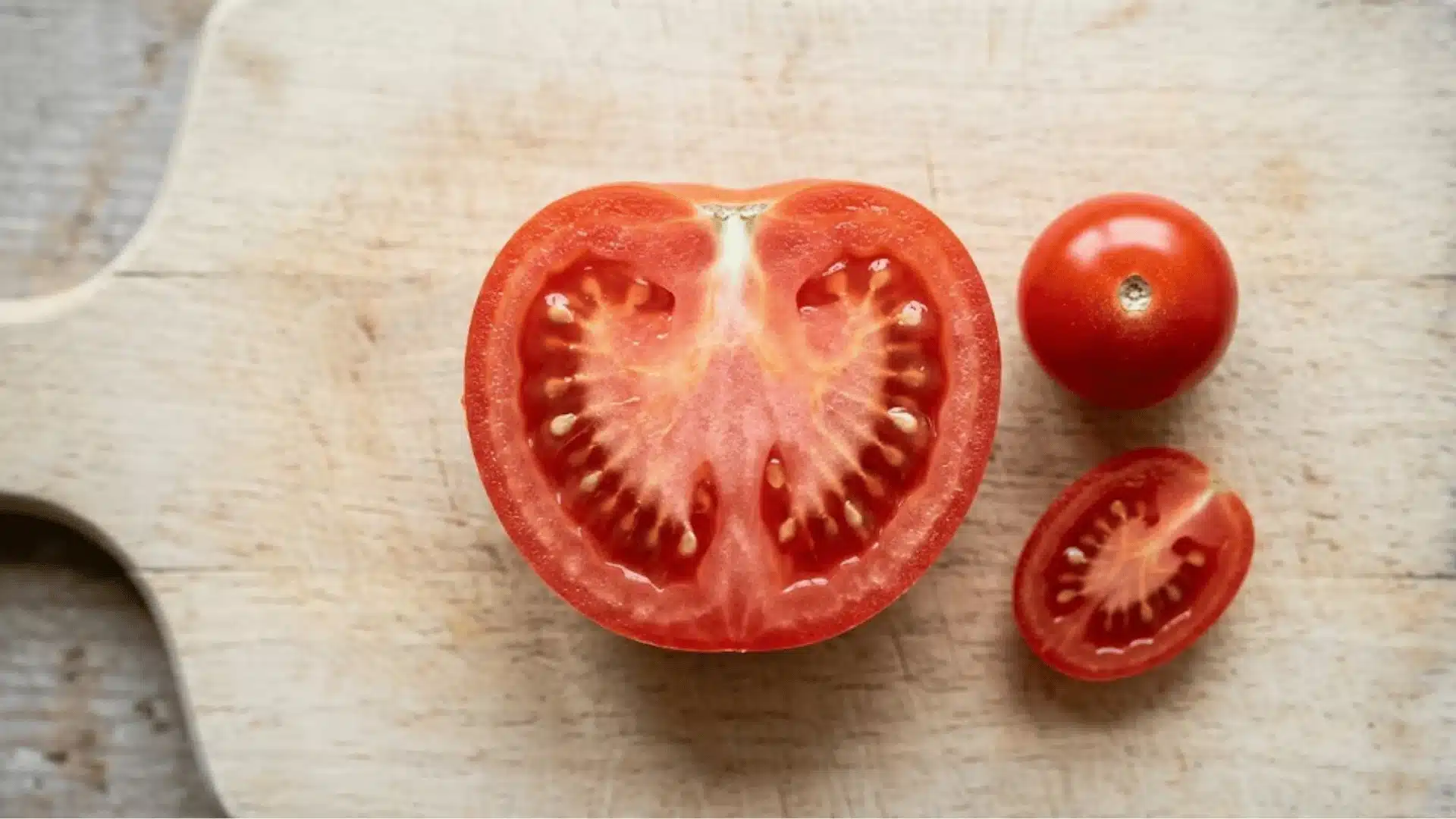 Sliced ripe tomatoes including cherry and Roma varieties safe for guinea pigs