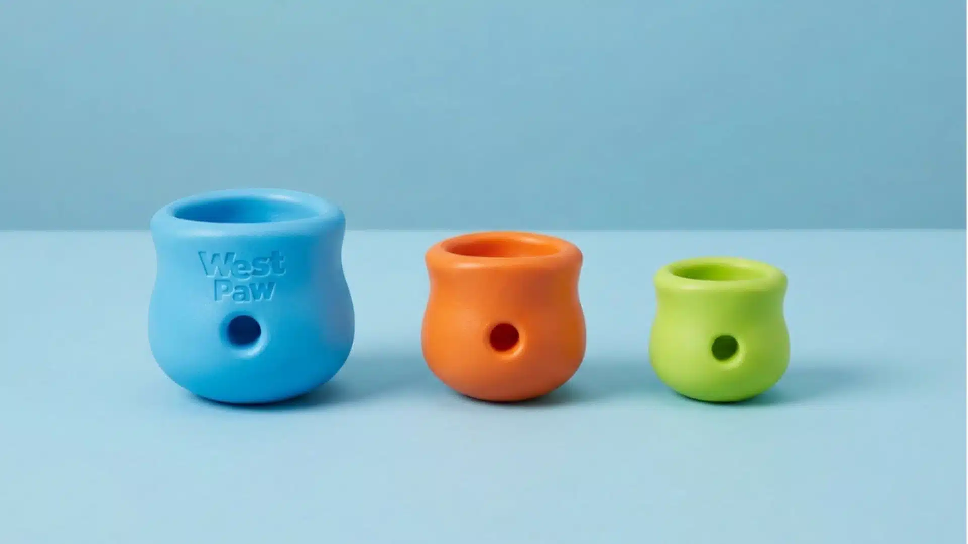 Three colorful West Paw Toppl dog treat toys